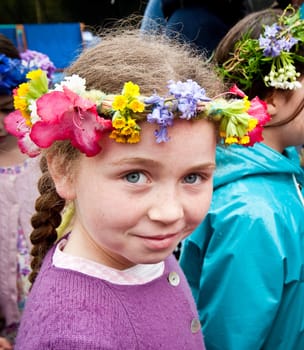 young girl with flower headband looking into camera