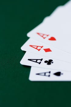 Playing cards - four aces on green background.