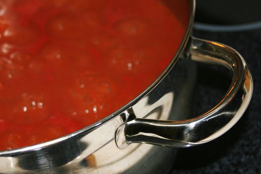 Red sauce in stainless steel pot sitting on stove