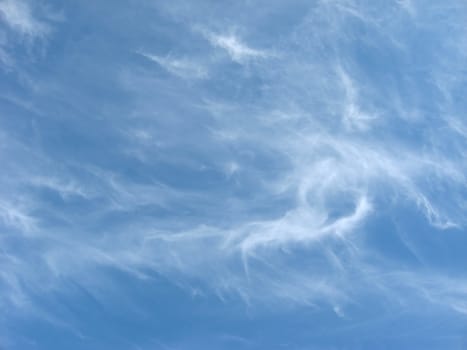 white whispy clouds against a blue sky