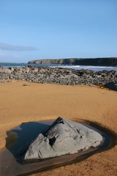 a golden sandy beach in ballybunion county kerry ireland with a rock pool