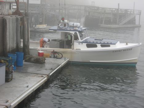on a foggy morning, a lobster boat at dock