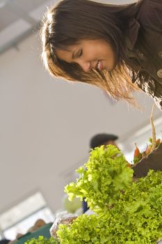 Interesting detail and perspective of a woman buying salad in a vegetables market.Shot with Canon 70-200mm f/2.8L IS USM