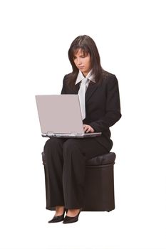 Businesswoman sitting on a chair and working on a laptop.