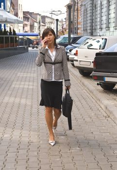 Businesswoman on the mobile phone in a city street.