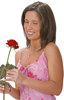 Smilling young woman enjoying a beautiful red rose.Shot with Canon 70-200mm f/2.8L IS USM