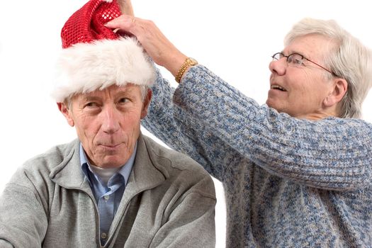 Woman putting a santa hat on her husbands head