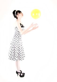 Portrait of a young beautiful brunette posing with yellow ball