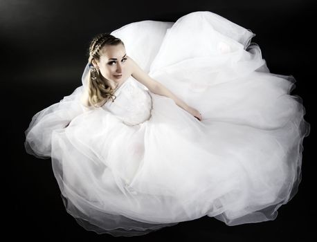 Young beautiful bride in wedding dress over black 