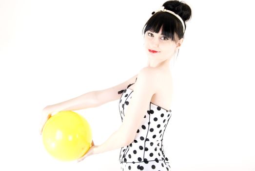 Portrait of a young beautiful brunette posing with yellow ball