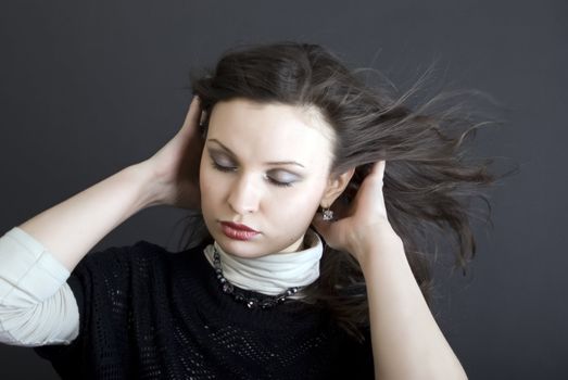 Portrait of a young beautiful brunette with the hair blowing about