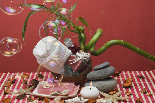 Still life about spa with some hygiene items in red and soap bubbles.