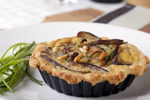 Small Quiche appetizer with shitake mushrooms and pine nuts.