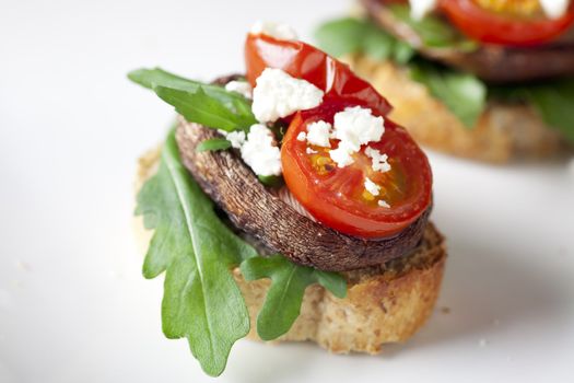 Shitake mushroom tapas with cherry tomatoes and crumbled  feta cheese.