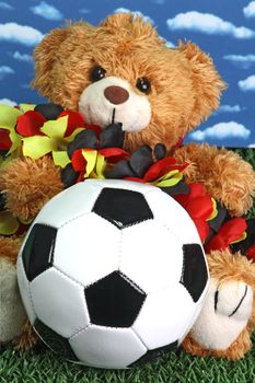 Cute teddy bear with a soccerball onb right background