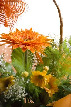 orange gerbera bouquet in basket over white