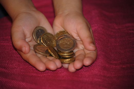 childs hand with euros