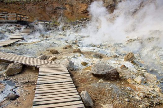 Wooden path in geothermal area in Iceland. Summer day.