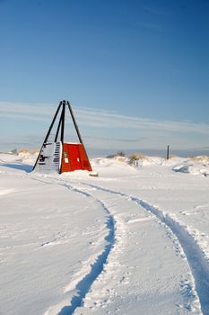 Car tracks in the snow by the beach