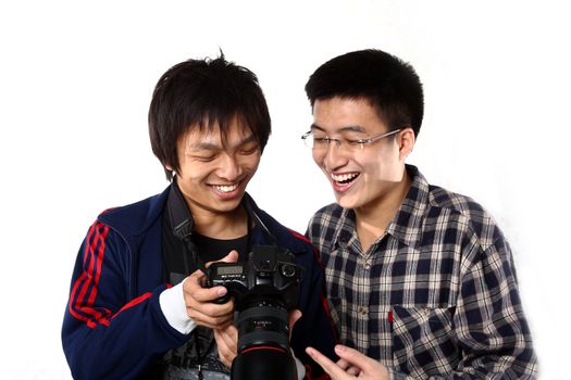 two asian man watching the photo in camera.