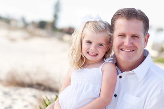 Cute Daughter Cuddles up with Her Handsome Dad at the Beach.