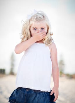 Adorable Blue Eyed Girl Covering Her Mouth Outside.