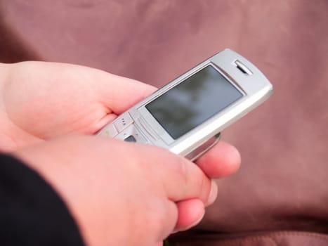 Human hands holding a modern cell phone with copy space
