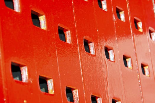 Square holes in stacked industrial red metal formwork