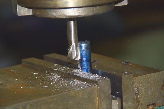 Industrial drill shaping a metal piece