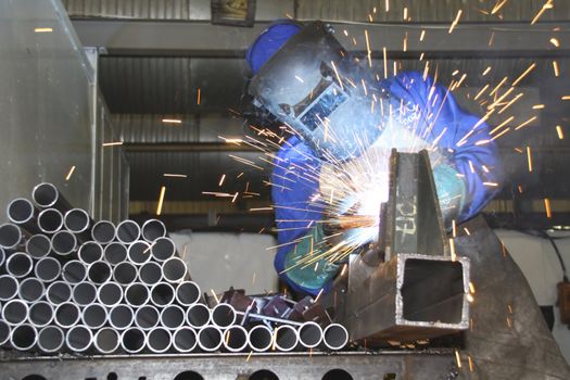 Artisan welding tubes and pipes on a production line