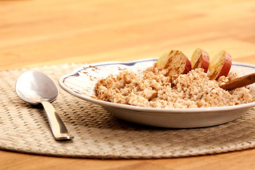 A bowl of apple cinnamon porridge on a wooden table.