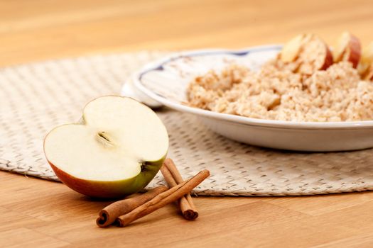 Apple Cinnamon Porridge - shallow depth of field with focus on the apple and cinnamon stick