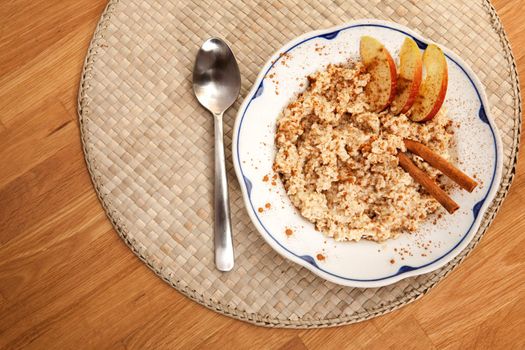 A bowl of porridge with apple and cinnamon spices