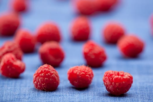 Fresh raspberries isolated on a blue cloth