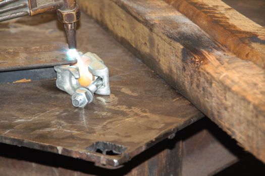 Acetylene torch throwing sparks as it cuts through a metal cornice