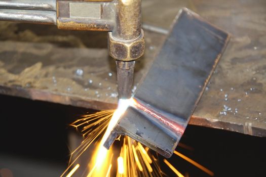 Acetylene torch throwing sparks as it cuts through a metal cornice