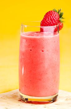 A fresh strawberry smoothie isolated over yellow