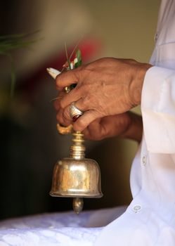 Ceremonial bell in hands of the priest