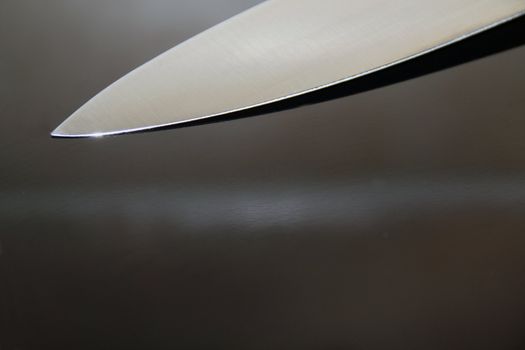 Knife blade on a reflective black surface