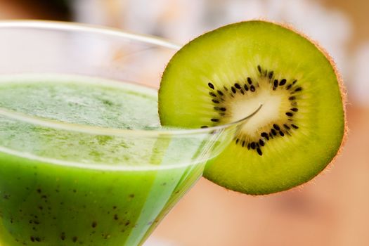 A tasty kiwi smoothie in a natural setting with macro detail on kiwi slice