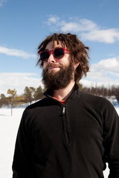 A funny portrait of a male with a full beard and sunglasses