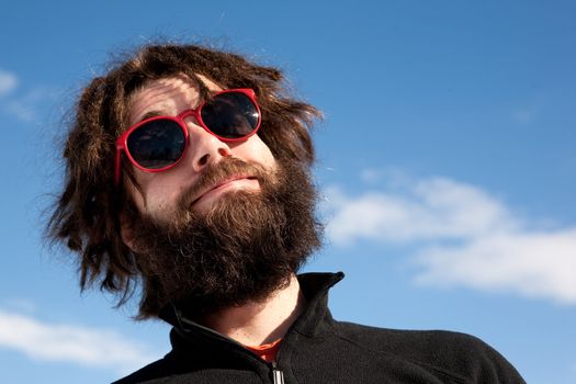 A funny portrait of a male with a full beard and sunglasses