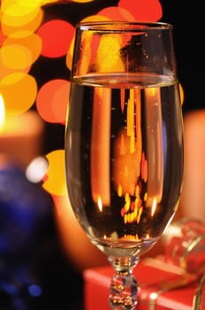 Wineglass with a champagne on a background of multicoloured sparks