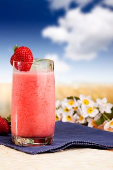 A fresh summer strawberry drink in an outdoor setting
