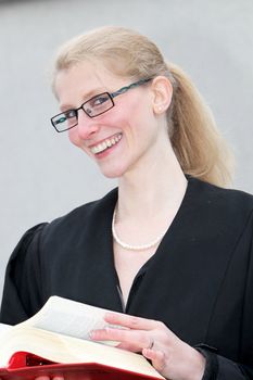 blonde, young, law student scrolls laughing in the book and looking towards camera
