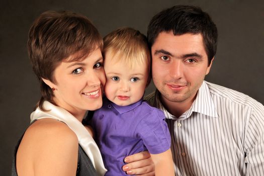 Happy young family with son in studio