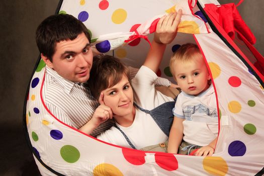 Happy young family with son in studio