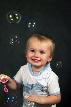 The small boy with soap bubbles in studio