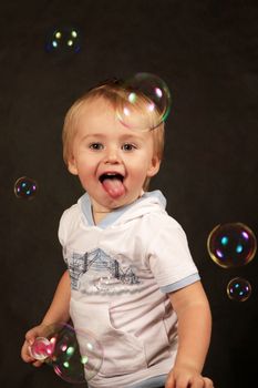 The small boy with soap bubbles in studio