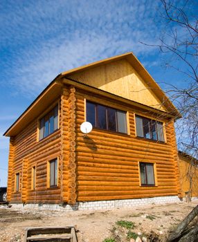 The wooden rural house against the blue sky